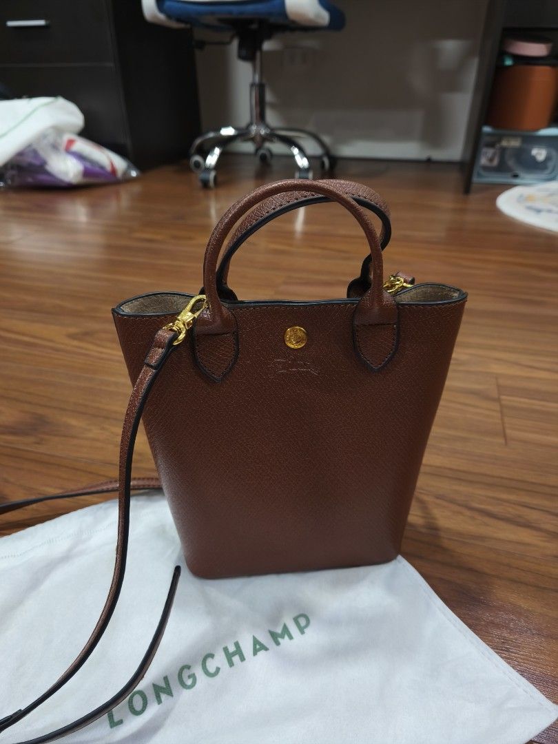 Longchamp Brown Handbag with Strap (Category: Luxury Bags & Wallets) located in Quezon City. Submitted by jhays02 (Listing ID 1433706357, Image 2). Description: - Longchamp handbag - Top handle and detachable strap - Textured exterior - Gold-tone clasp - Interior pocket - Includes dust bag.