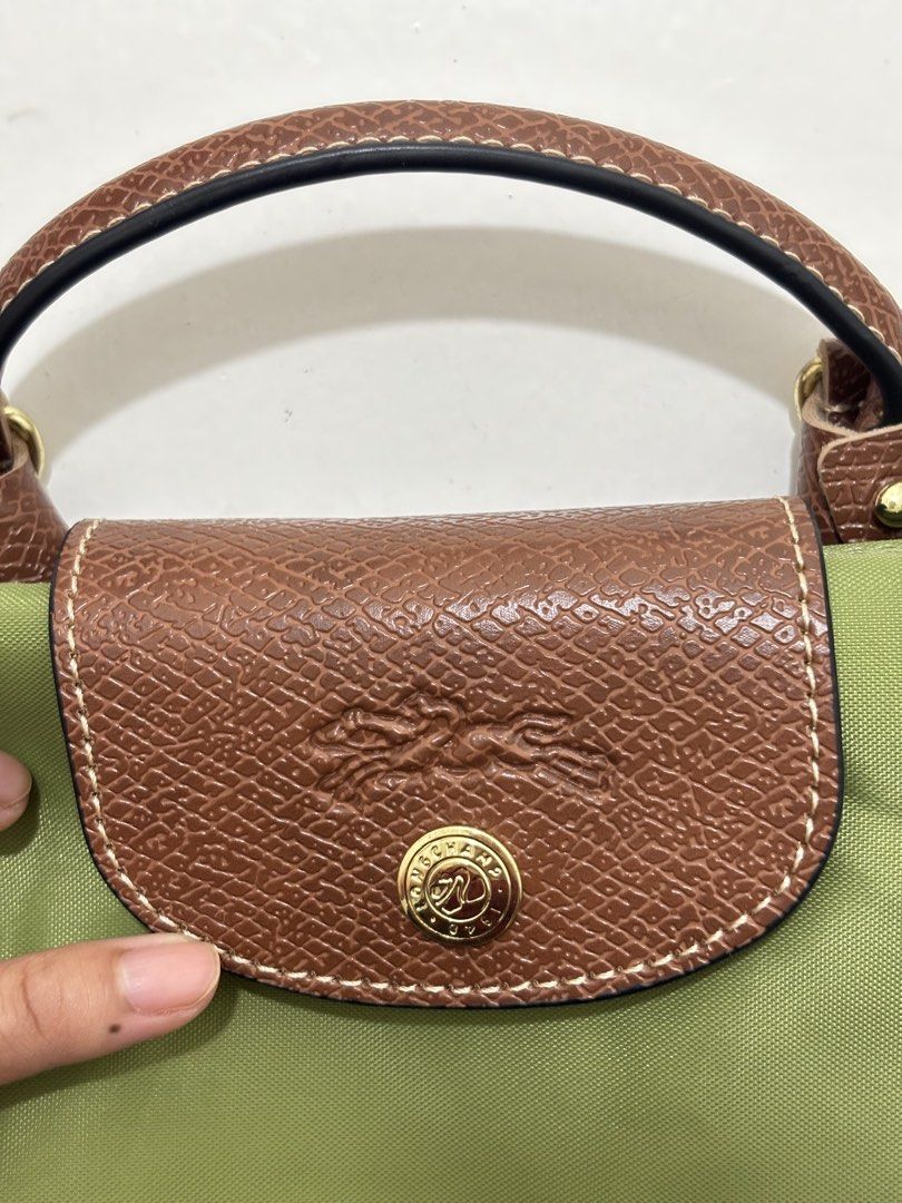 Longchamp Le Pliage Cuir Mini Top Handle Bag (Category: Luxury Bags & Wallets) located in Dagupan City. Submitted by raregrail.co (Listing ID 1433698351, Image 3). Description: - Authentic Longchamp Le Pliage Cuir Mini Top Handle Bag - Color: Olive Green - Features: Brown leather flap and handle, detachable shoulder strap - Made in France - Closure: Zip and snap closure - Interior tag with Longchamp Paris logo.