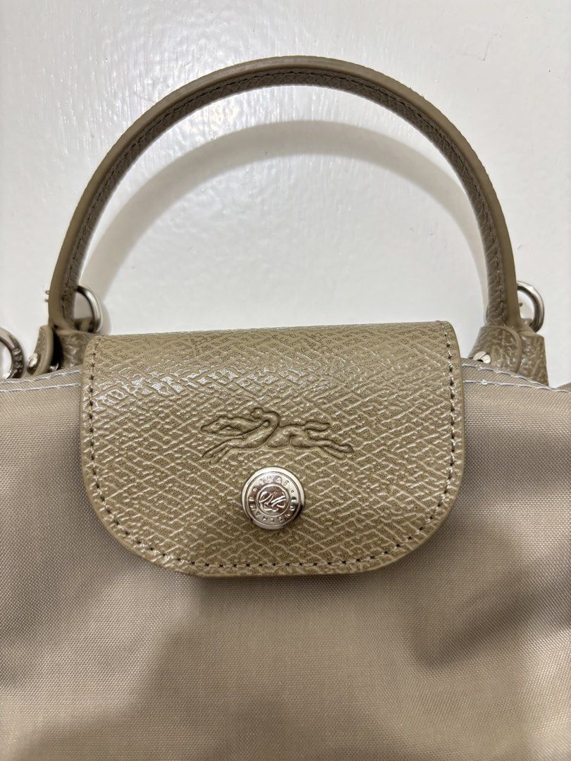 Longchamp Le Pliage Cuir XS Handbag (Category: Luxury Bags & Wallets) located in Dagupan City. Submitted by raregrail.co (Listing ID 1433698778, Image 3). Description: - Authentic Longchamp Le Pliage Cuir XS handbag - Top handle and detachable shoulder strap - Flap closure with snap button - Interior includes a small pocket - Made in France - Neutral color with green accents.