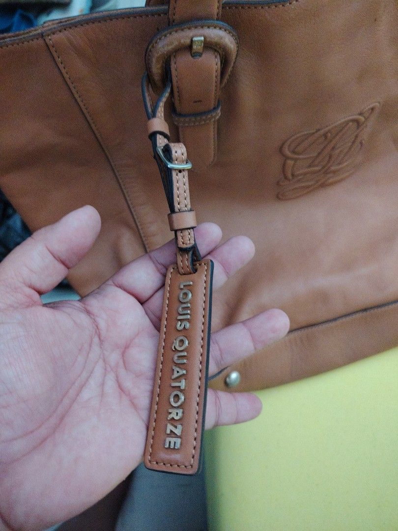 Louis Quatorze Leather Tote Bag (Category: Tote Bags) located in Taguig. Submitted by roxie0419 (Listing ID 1433651390, Image 3). Description: - Authentic Louis Quatorze tote bag - Genuine leather - Color: Tan - Spacious interior - Multiple compartments - Patterned lining - Detachable brand tag - Embossed logo - Double handles - Decorative buckles - Metal studs on the bottom SF c/o buyer MOP GCash or Maya COP via LBC.