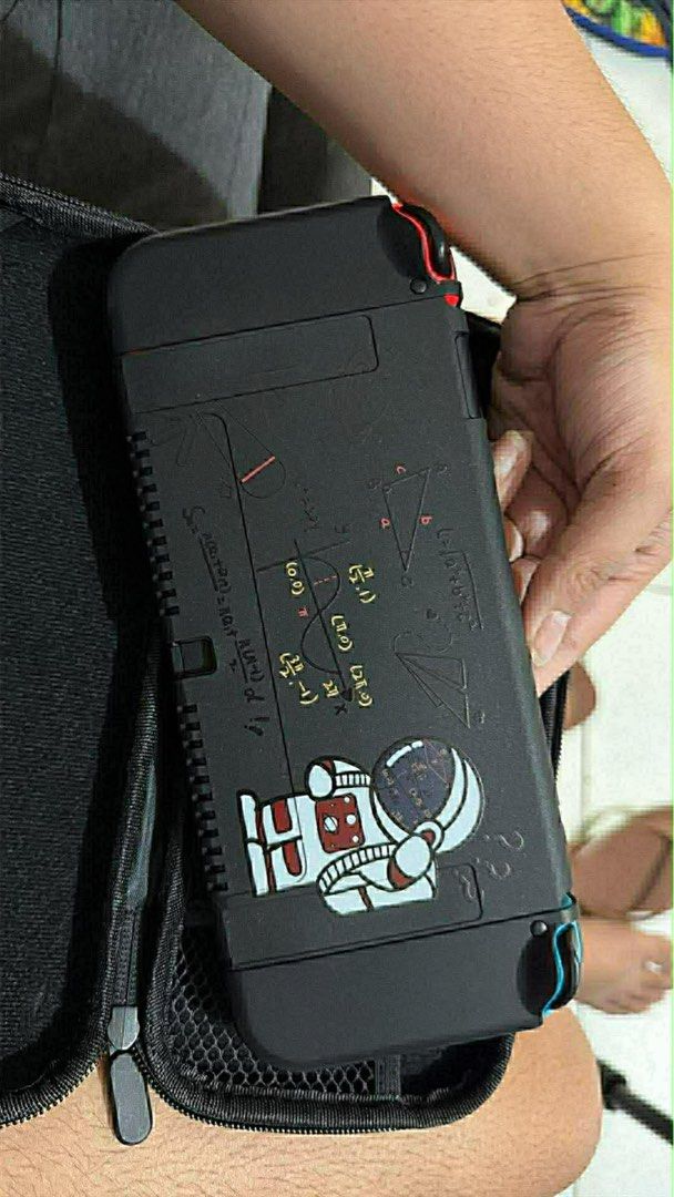 Nintendo Switch Console with Accessories (Category: Nintendo) located in Manila. Submitted by jmcatubag38280 (Listing ID 1433665194, Image 2). Description: - Nintendo Switch console - Red and blue Joy-Con controllers - Charging cable - Carrying case (black exterior with astronaut design) - Power adapter - Other accessories (as shown).