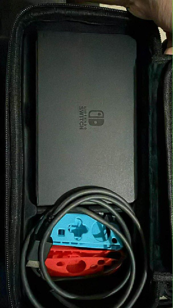Nintendo Switch Console with Accessories (Category: Nintendo) located in Manila. Submitted by jmcatubag38280 (Listing ID 1433665194, Image 3). Description: - Nintendo Switch console - Red and blue Joy-Con controllers - Charging cable - Carrying case (black exterior with astronaut design) - Power adapter - Other accessories (as shown).