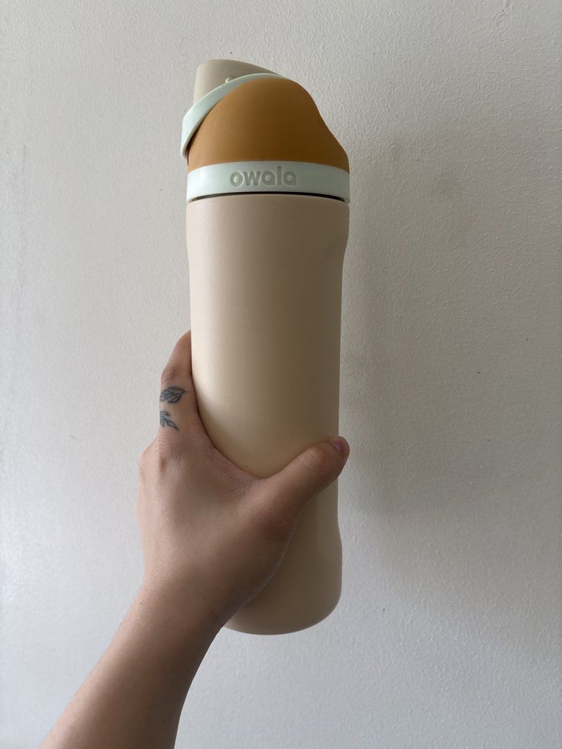 Owala FreeSip Water Bottle 24oz Water Desert (Category: Water Bottles & Tumblers) located in Taguig. Submitted by anik.ph (Listing ID 1433590142, Image 2). Description: - Owala FreeSip water bottle - Color scheme: Tan body, brown top, mint green accent - Features the Owala logo - Made of durable material - Includes a convenient handle - Designed to keep drinks cold - Ideal for everyday use - w flaws, if any, barely noticeable .