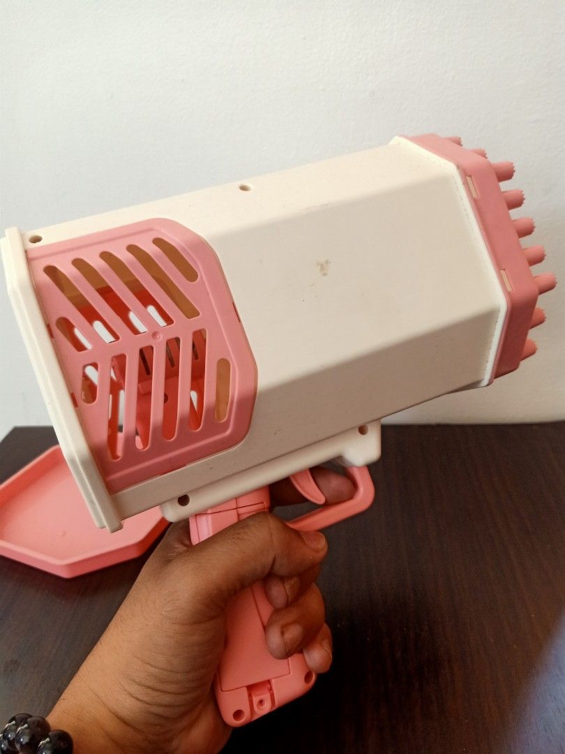 Pink Bubble Gun (Category: Kids Toys) located in Las Pinas. Submitted by the_recycle_shop (Listing ID 1433629827, Image 3). Description: - Pink bubble gun - Includes octagonal tray - White and pink color scheme - Features a trigger and multi-hole nozzle.