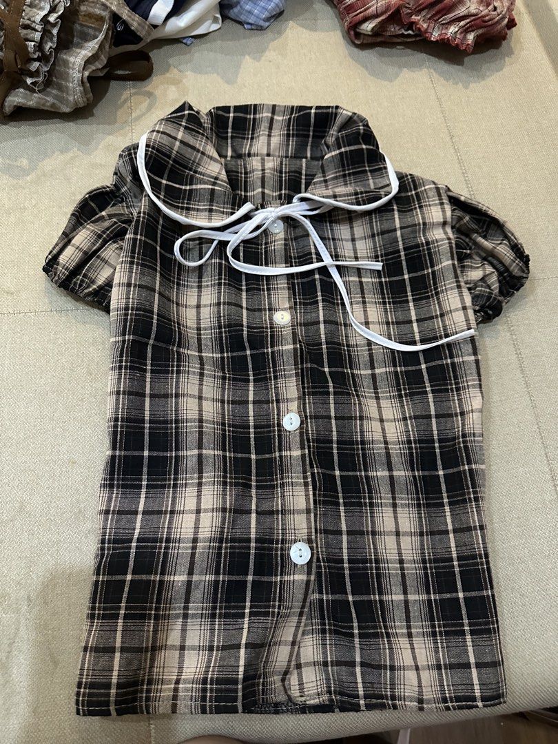 Plaid Blouse with Tie Detail (Category: Blouses) located in Manila. Submitted by imunchoneverything (Listing ID 1433640399, Image 1). Description: - Black and beige plaid pattern - Peter Pan collar with white trim - Tie detail - Short, puffed sleeves - Button-down front - Back tie for a fitted silhouette Jnt or lalamove (if jnt, you have to book) Gcash or payment only.