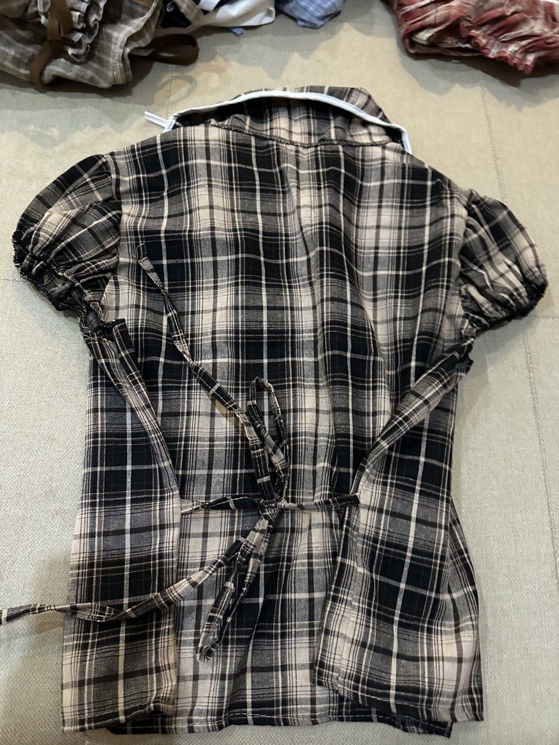 Plaid Blouse with Tie Detail (Category: Blouses) located in Manila. Submitted by imunchoneverything (Listing ID 1433640399, Image 2). Description: - Black and beige plaid pattern - Peter Pan collar with white trim - Tie detail - Short, puffed sleeves - Button-down front - Back tie for a fitted silhouette Jnt or lalamove (if jnt, you have to book) Gcash or payment only.