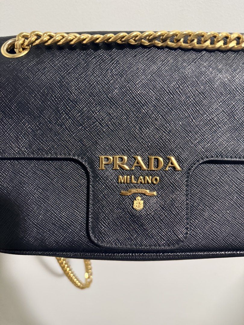 Prada Saffiano crossbody Chain Bag (Category: Luxury Bags & Wallets) located in Quezon City. Submitted by 0628_ (Listing ID 1433642746, Image 1). Description: - Authentic Prada Saffiano Cross body Chain Bag - Gold-tone hardware - Chain strap with leather shoulder rest - Interior: Zippered pocket, Prada logo lining - Includes: Authenticity cards, dust bag - Magnetic snap closure Flaws: minor creasing Rfs: decluttering.