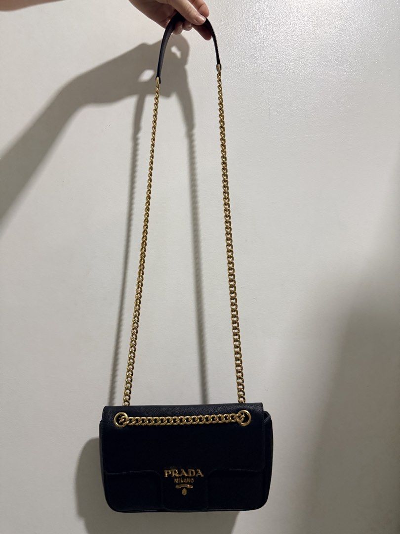 Prada Saffiano crossbody Chain Bag (Category: Luxury Bags & Wallets) located in Quezon City. Submitted by 0628_ (Listing ID 1433642746, Image 3). Description: - Authentic Prada Saffiano Cross body Chain Bag - Gold-tone hardware - Chain strap with leather shoulder rest - Interior: Zippered pocket, Prada logo lining - Includes: Authenticity cards, dust bag - Magnetic snap closure Flaws: minor creasing Rfs: decluttering.