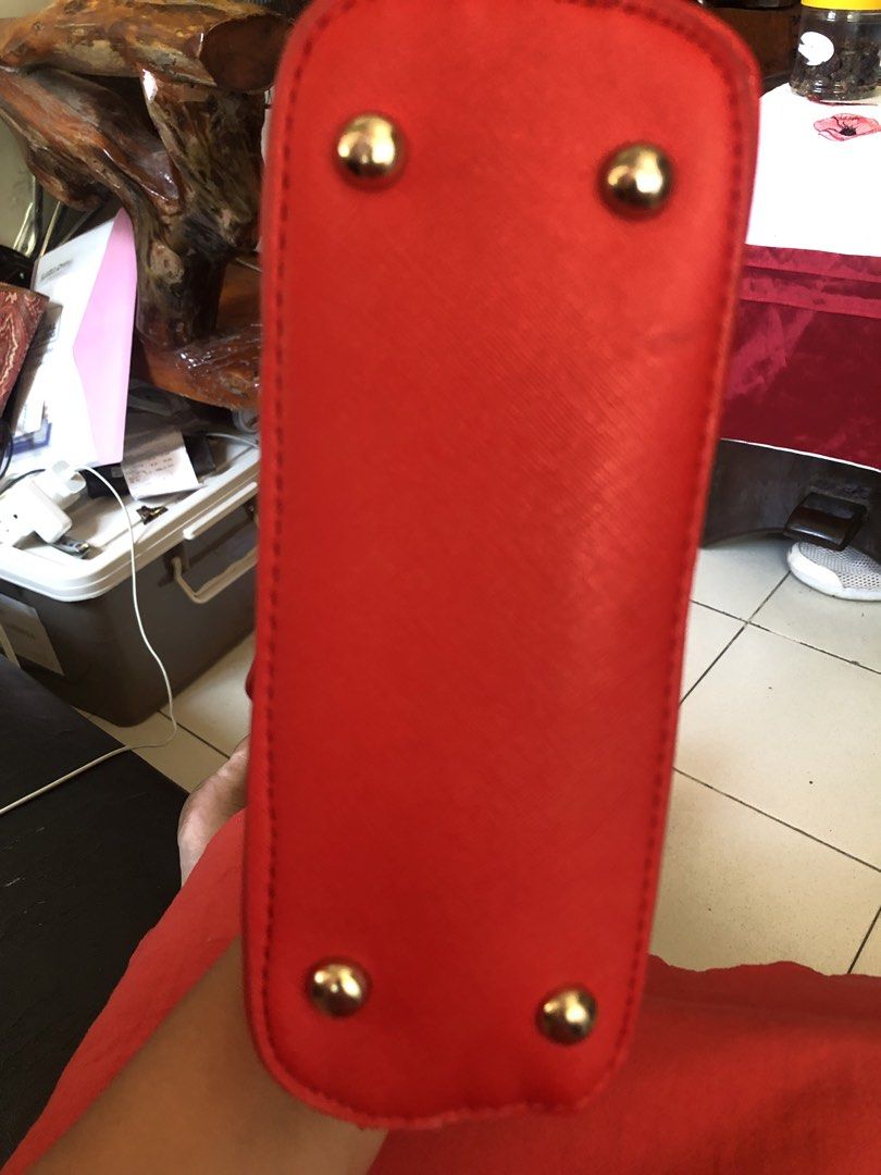 Red Handbag with Gold Studs (Category: Luxury Bags & Wallets) located in Tabuk. Submitted by qurst (Listing ID 1433632103, Image 3). Description: - Vibrant red handbag - Gold studs on the bottom - Smooth material - Rectangular shape - Well-made stitching.