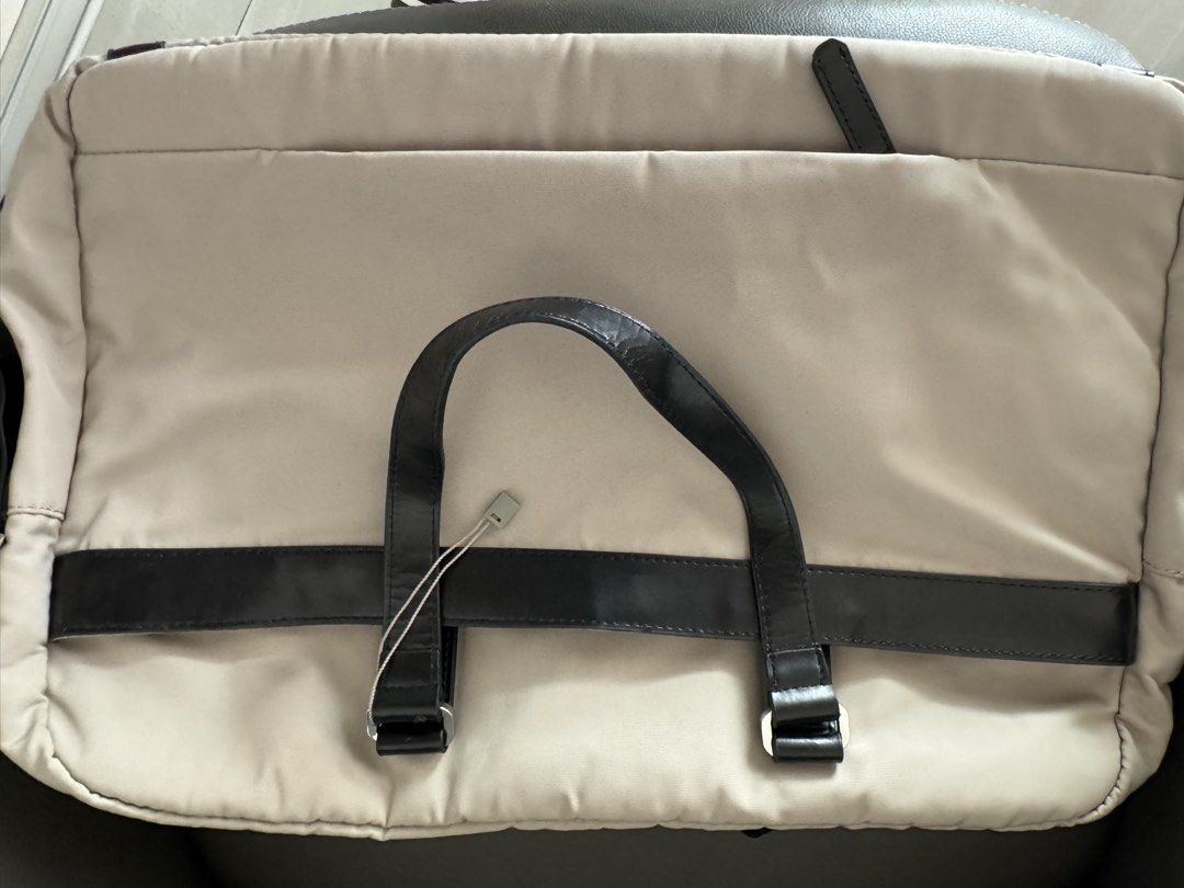 Samsonite Beige laptop Bag (Category: Laptop Bags & Sleeves) located in Makati City. Submitted by gonz4669 (Listing ID 1433584815, Image 3). Description: - Samsonite laptop bag - Beige exterior with black leather accents - Dual top handles - Multiple interior compartments - Includes a padded section - Gray interior lining - Secure zipper closure - Samsonite logo detail - slightly cracking on PU accents.