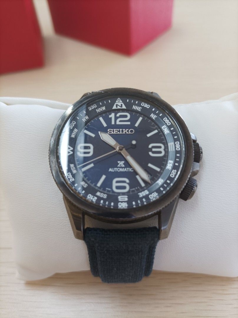 Seiko Automatic Watch (Category: Men's Watches) located in Cebu City. Submitted by mac_j003 (Listing ID 1433680039, Image 1). Description: Seiko automatic watch features a dark blue dial with luminous hands and markers. It has a rotating bezel with compass markings. The watch has a black strap. The back of the watch is transparent, revealing the movement. The watch has a date display at the 3 o'clock position..