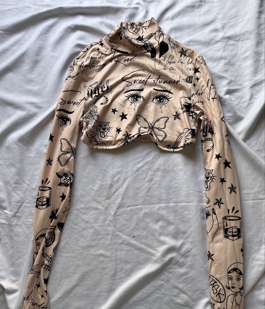 Shein Tattoo Print Crop Top (Category: Others Tops) located in Las Pinas. Submitted by nixxxxx (Listing ID 1433672567, Image 1). Description: - Shein crop top - Used once - Unique tattoo print design - Long sleeves - Mock neck - Beige color with black tattoo graphics.