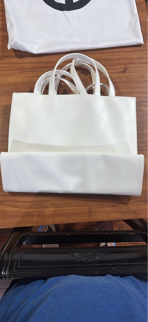 Telfar Shopping Bag White (Category: Luxury Bags & Wallets) located in Manila. Submitted by rods10 (Listing ID 1433758919, Image 3). Description: - White Telfar Shopping Bag - Features Telfar logo - Includes dust bag and tags - Double handles - Rectangular shape - Multiple interior compartments - Includes matching white pouch.