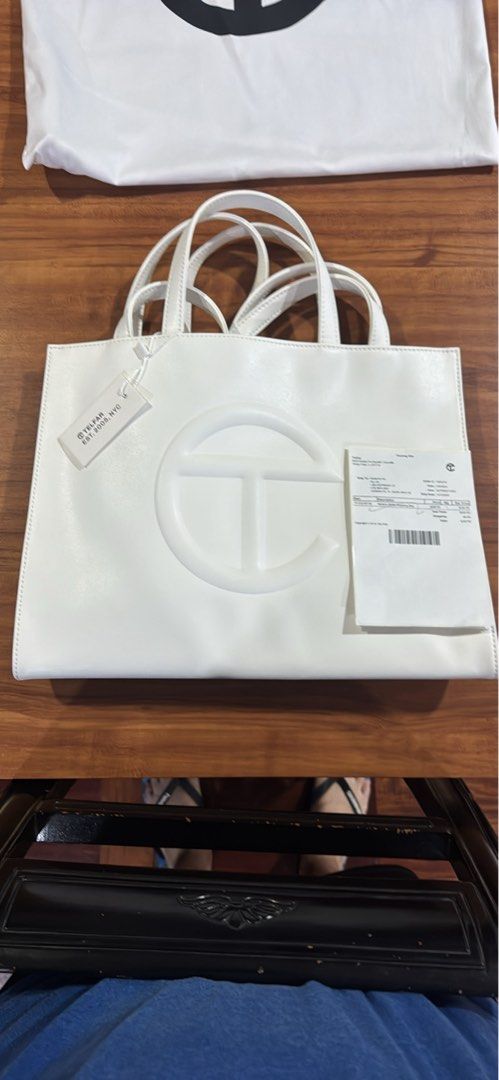 Telfar Shopping Bag White (Category: Luxury Bags & Wallets) located in Manila. Submitted by rods10 (Listing ID 1433758919, Image 2). Description: - White Telfar Shopping Bag - Features Telfar logo - Includes dust bag and tags - Double handles - Rectangular shape - Multiple interior compartments - Includes matching white pouch.