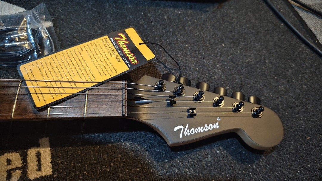 Thomson Electric Guitar with Case electric guitar (Category: Musical Instruments) located in Pasig City. Submitted by tupriomichaeljohn (Listing ID 1433661993, Image 3). Description: - Thomson electric guitar - Sunburst finish - Includes gig bag and cable - Tremolo system - Three pickups - Rosewood fretboard - Black pickguard - Thomson logo on headstock.