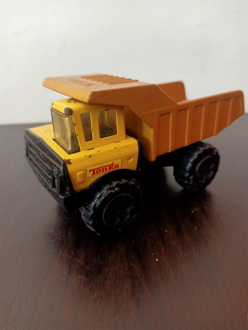 Tonka Dump Truck (Category: Vehicle & Diecast Models) located in Las Pinas. Submitted by the_recycle_shop (Listing ID 1433630967, Image 1). Description: - Classic Tonka dump truck - Yellow cab and brown dump bed - Black wheels - Tonka logo visible - Dump bed raises - Model number: 812789-A - Tonka Corp. logo on underside.
