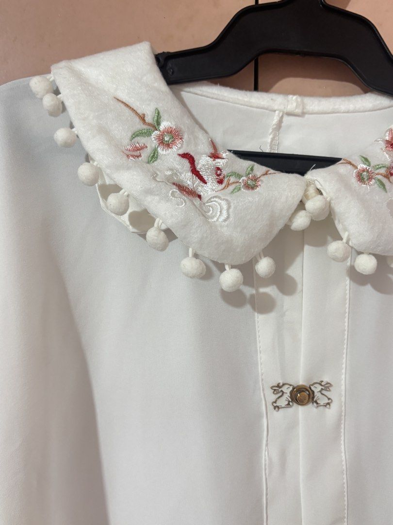White Embroidered Peter pan Collar Blouse (Category: Blouses) located in San Mateo. Submitted by angelthings.cute (Listing ID 1433677520, Image 2). Description: - Elegant white blouse - Embroidered collar with pom-pom trim - Long sleeves - Decorative button closures - Floral embroidery on collar - Slight flare on sleeves - Lightweight fabric.