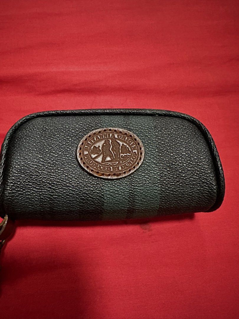 Britannia Origin Key Pouch (Category: Purses & Pouches) located in Antipolo. Submitted by happinessprelove (Listing ID 1433912026, Image 2). Description: - Britannia Origin key pouch - Dark green and black striped design - Features a brown leather patch - Secure zipper closure - Includes a metal clasp - Britannia Origin logo visible - Compact and stylish design.