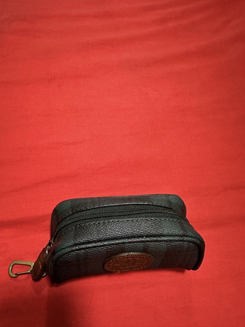 Britannia Origin Key Pouch (Category: Purses & Pouches) located in Antipolo. Submitted by happinessprelove (Listing ID 1433912026, Image 3). Description: - Britannia Origin key pouch - Dark green and black striped design - Features a brown leather patch - Secure zipper closure - Includes a metal clasp - Britannia Origin logo visible - Compact and stylish design.