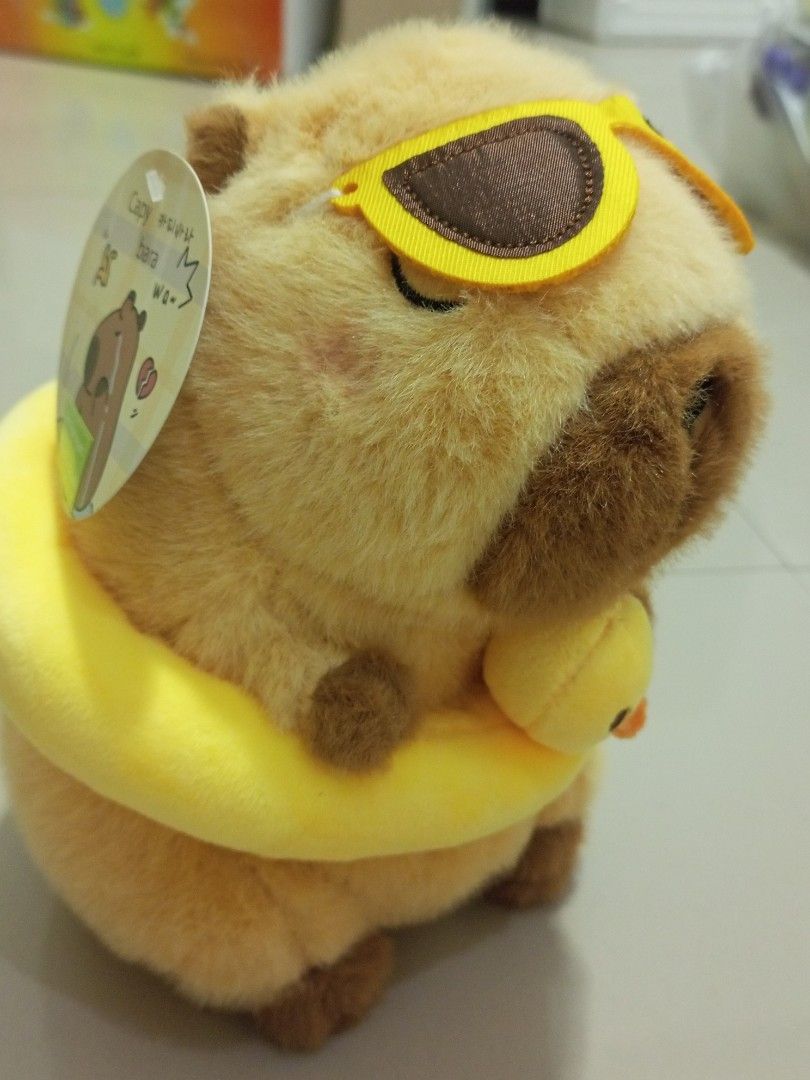 Capybara Plush Toy with Sunglasses (Category: Plushies & Soft Toys) located in Manila. Submitted by kb_kg (Listing ID 1433790453, Image 2). Description: - Adorable capybara plush toy - Wearing sunglasses and a yellow floatie - Includes a small duck attached to the floatie - Light brown and beige color scheme - Comes with a tag - Perfect for collectors or as a gift.