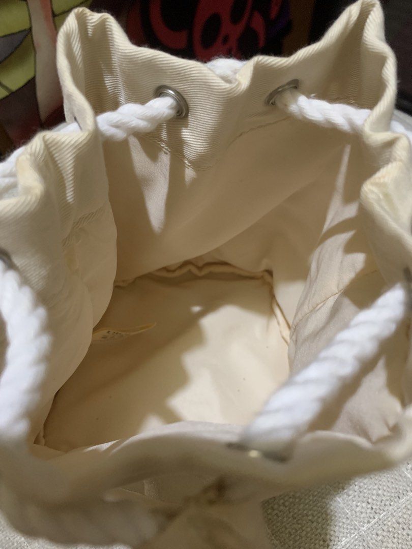 Cream Drawstring Bag (Category: Backpacks) located in Quezon City. Submitted by ncjnc (Listing ID 1433797541, Image 3). Description: - Cream-colored drawstring bag - White rope drawstring closure - White embroidered logo - Cylindrical shape with flat bottom - Clean interior - Light cream exterior fabric.