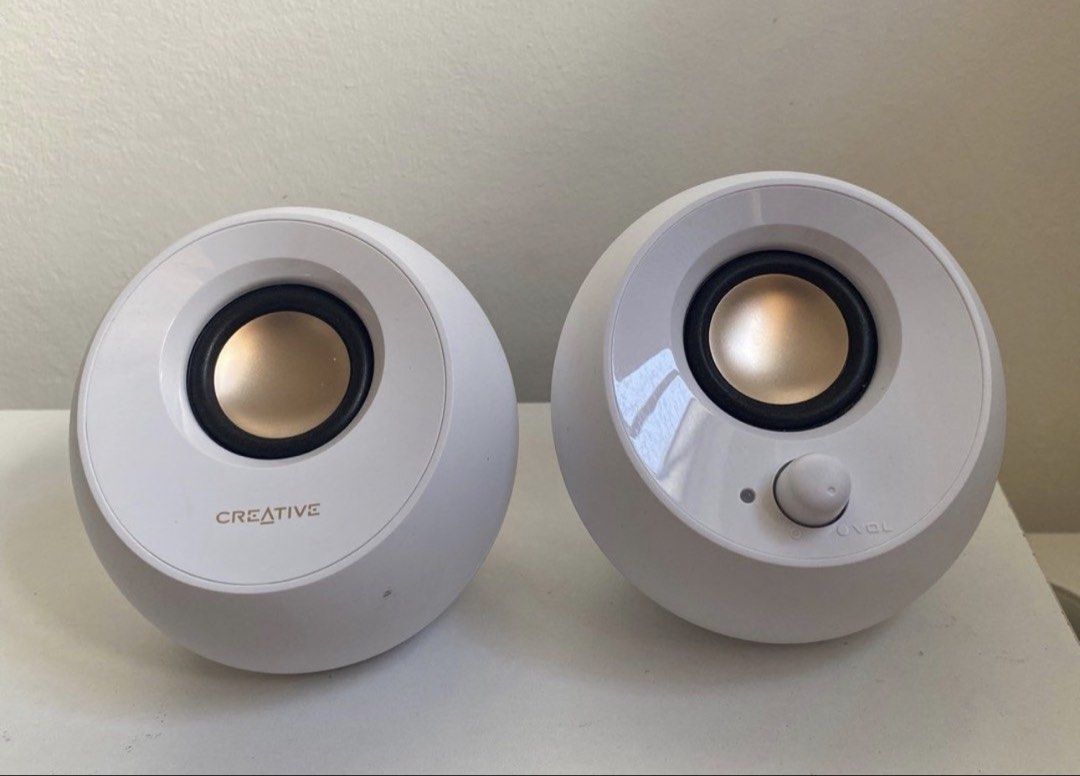 Creative Pebble Speakers (Category: Soundbars, Speakers & Amplifiers) located in Quezon City. Submitted by annalizadm56552 (Listing ID 1433798361, Image 1). Description: - Creative Pebble speakers - Sleek, modern design - Color: White with gold speaker cones - Volume control knob - Includes attached cables - Creative logo visible.