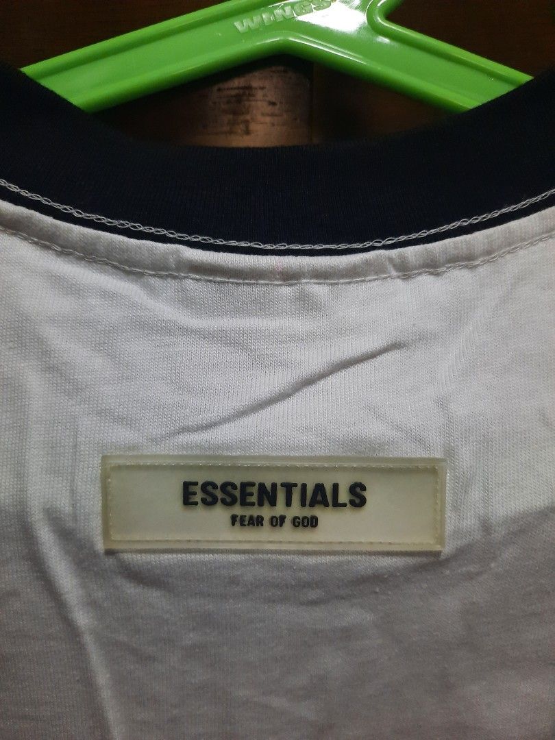 Essentials Fear of God 77 T-shirt (Category: Tshirts & Polo Shirts ) located in Makati City. Submitted by fiercecat_1521ja (Listing ID 1433884035, Image 3). Description: - White t-shirt with black accents - Features "ESSENTIALS" printed on the front - Includes "77" in large black font - Black collar and sleeve trim - Size: S (for men's size) - Comes with original tag.
