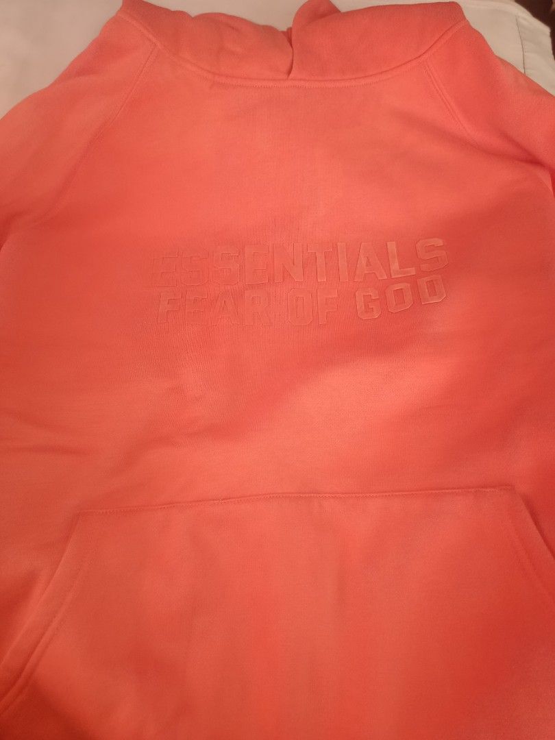 Essentials Fear of God Hoodie (Category: Hoodies) located in Caloocan City. Submitted by livedeer-1208c7 (Listing ID 1433823382, Image 1). Description: - Essentials Fear of God hoodie - Coral/Salmon color - Features the Essentials logo on the front - Kangaroo pocket - Hood - Essentials label visible inside.