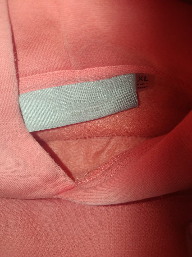 Essentials Fear of God Hoodie (Category: Hoodies) located in Caloocan City. Submitted by livedeer-1208c7 (Listing ID 1433823382, Image 3). Description: - Essentials Fear of God hoodie - Coral/Salmon color - Features the Essentials logo on the front - Kangaroo pocket - Hood - Essentials label visible inside.