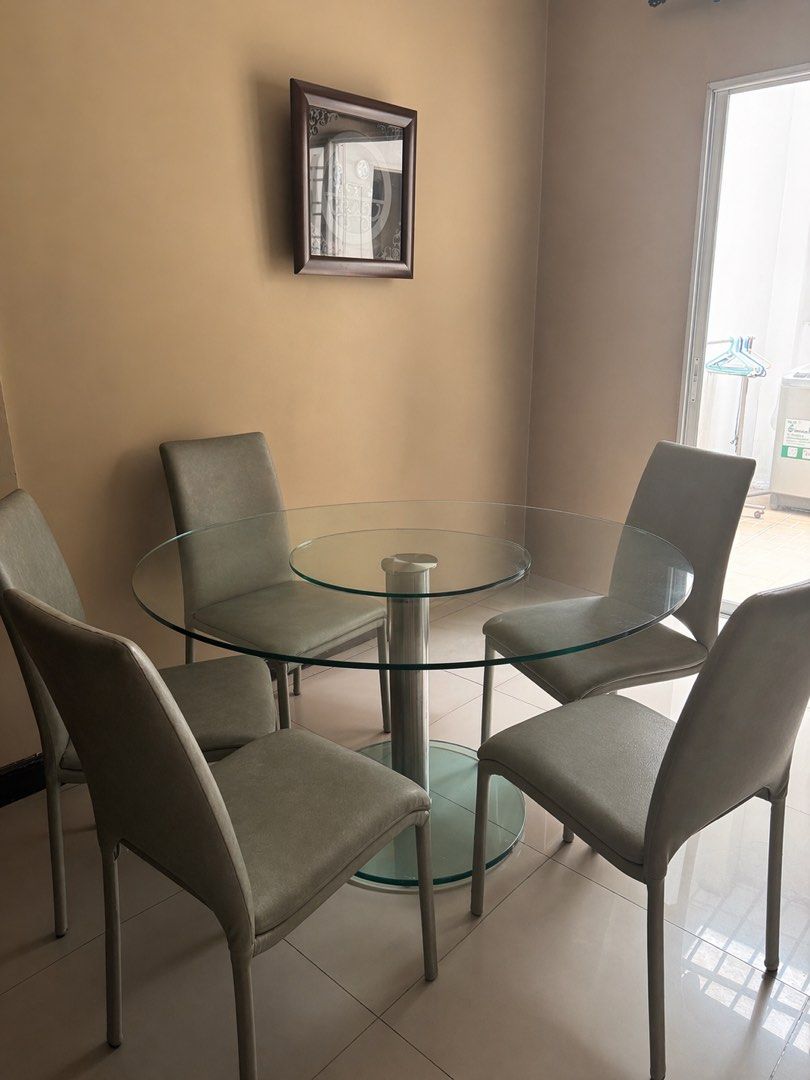 Glass Dining Table with 4 Chairs (Category: Tables & Sets) located in Quezon City. Submitted by flowercharm (Listing ID 1433885991, Image 3). Description: - Round glass dining table with chrome support - Includes six matching chairs - Chairs have light gray upholstered seat and back - Ideal for small spaces - Offers a modern and stylish aesthetic - From DECOR.