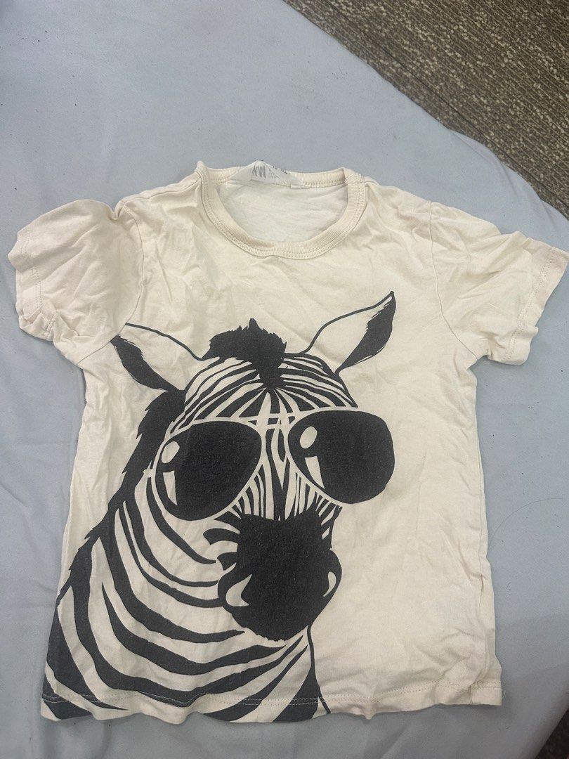 H&M Zebra Graphic T-shirt (Category: Babies & Kids Fashion) located in Quezon City. Submitted by heyyjaaay (Listing ID 1433800117, Image 1). Description: - H&M t-shirt with a fun zebra graphic. - Features a classic crew neck and short sleeves. - Size: EUR 98/104 (US 3/4T, CA 2-4A, CN 110/50, UK 2-4A). - Color: Off-white..