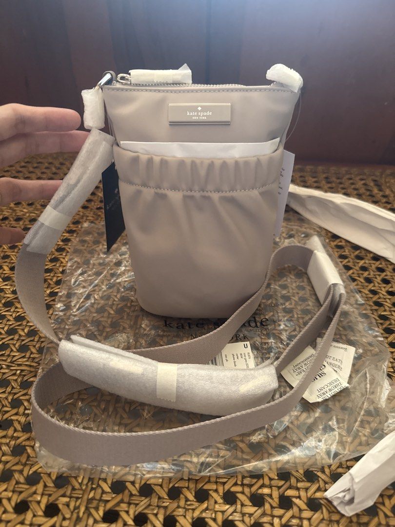Kate Spade Phone Crossbody Bag (Category: Cross-body Bags) located in Binan City. Submitted by toppicks715 (Listing ID 1433866933, Image 2). Description: - Kate Spade crossbody bag - Cozy gray color - VERY NICE COLOR!😍 - Compact design - Main compartment with zipper closure - Exterior pocket - Adjustable strap with Kate Spade logo - Brand new with tags - Original packaging.