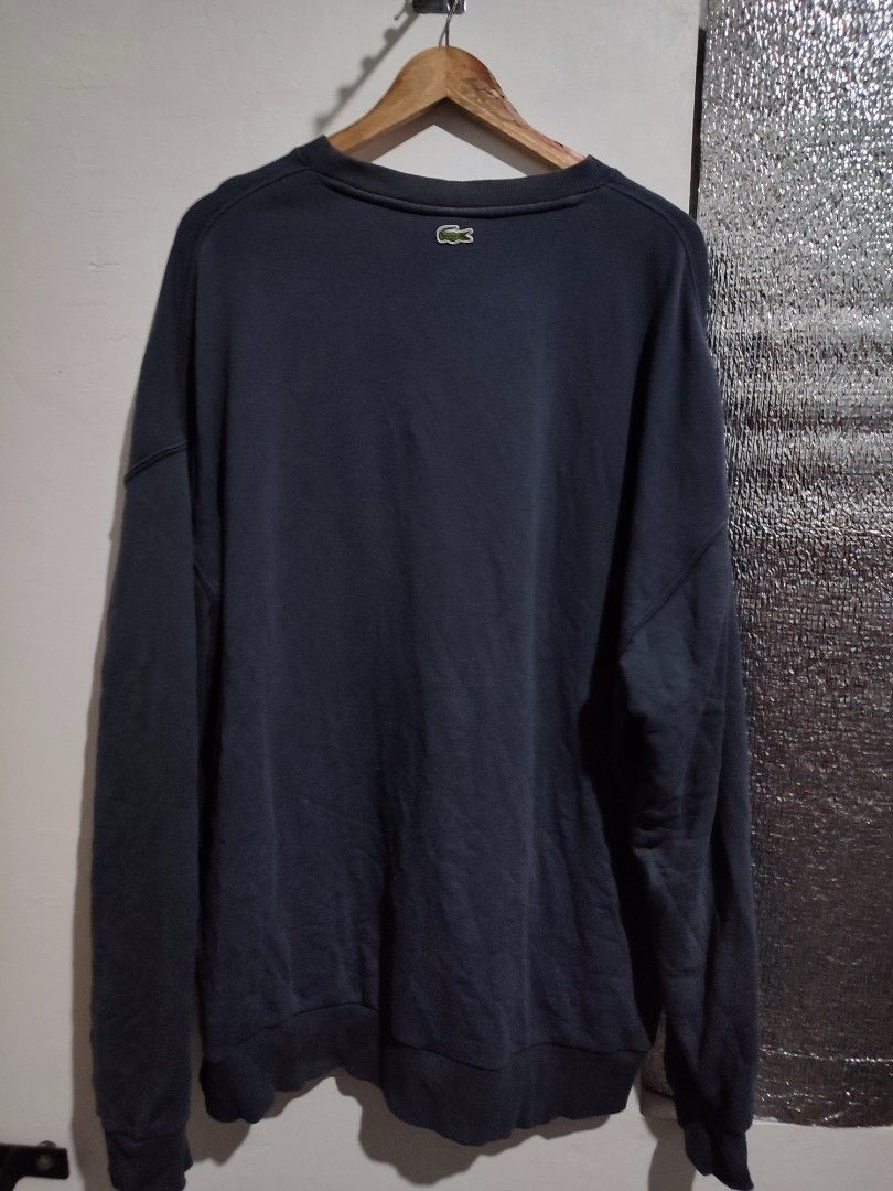 Lacoste Crewneck Sweatshirt (Category: Coats, Jackets and Outerwear) located in Caloocan City. Submitted by solestreetclub (Listing ID 1433840581, Image 3). Description: - Dark blue Lacoste crewneck sweatshirt - Features Lacoste logo on front - Shield design with green and purple stripes - Small Lacoste logo on back - Classic crew neck - Long sleeves Dimes: 24-25 X 30 Color: Gray Color rate: 9.5 / 10.