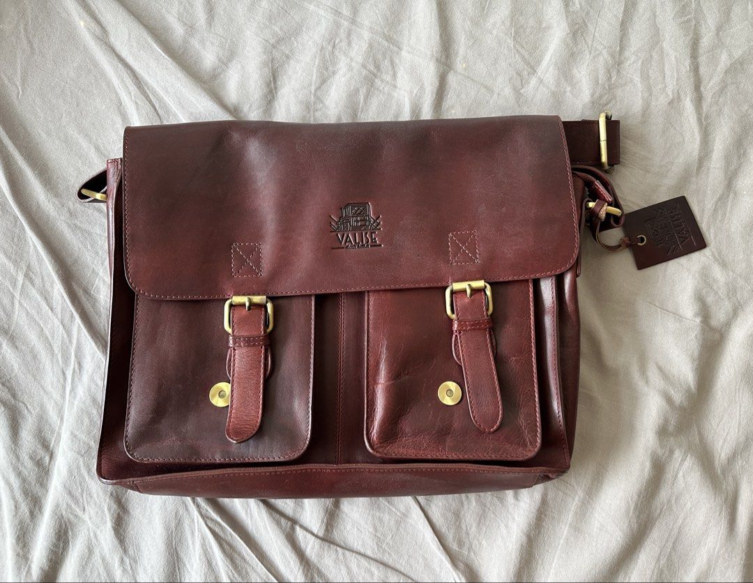 Leather Satchel Bag (Category: Sling Bags) located in Muntinlupa City. Submitted by emanuelthings (Listing ID 1433893567, Image 1). Description: - Valise genuine leather satchel bag - Cherry red exterior - Two front pockets - Secure flap closure with buckles - Plaid interior lining - Interior zippered pocket - Detachable shoulder strap - Spacious main compartment - Multiple pockets for organization.