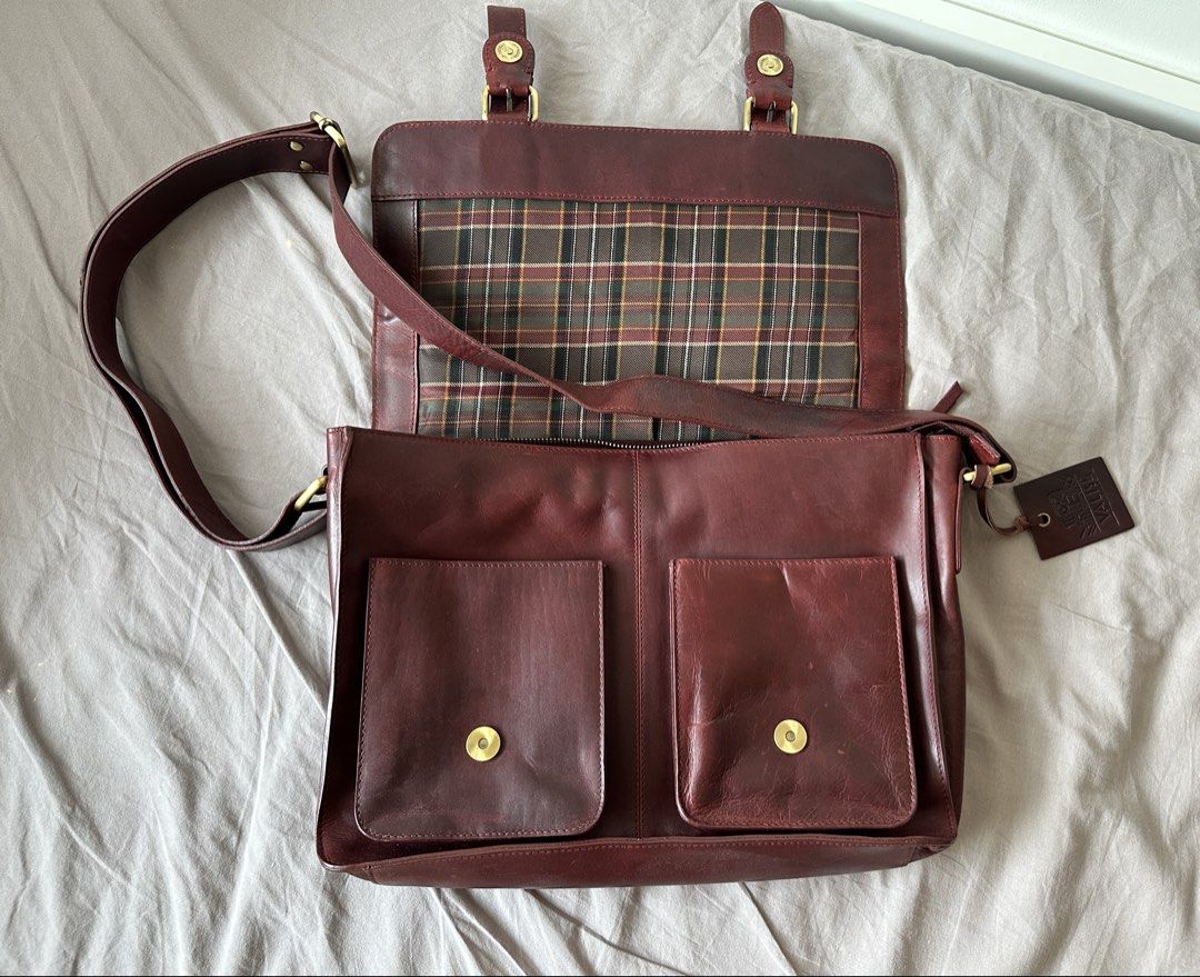 Leather Satchel Bag (Category: Sling Bags) located in Muntinlupa City. Submitted by emanuelthings (Listing ID 1433893567, Image 2). Description: - Valise genuine leather satchel bag - Cherry red exterior - Two front pockets - Secure flap closure with buckles - Plaid interior lining - Interior zippered pocket - Detachable shoulder strap - Spacious main compartment - Multiple pockets for organization.