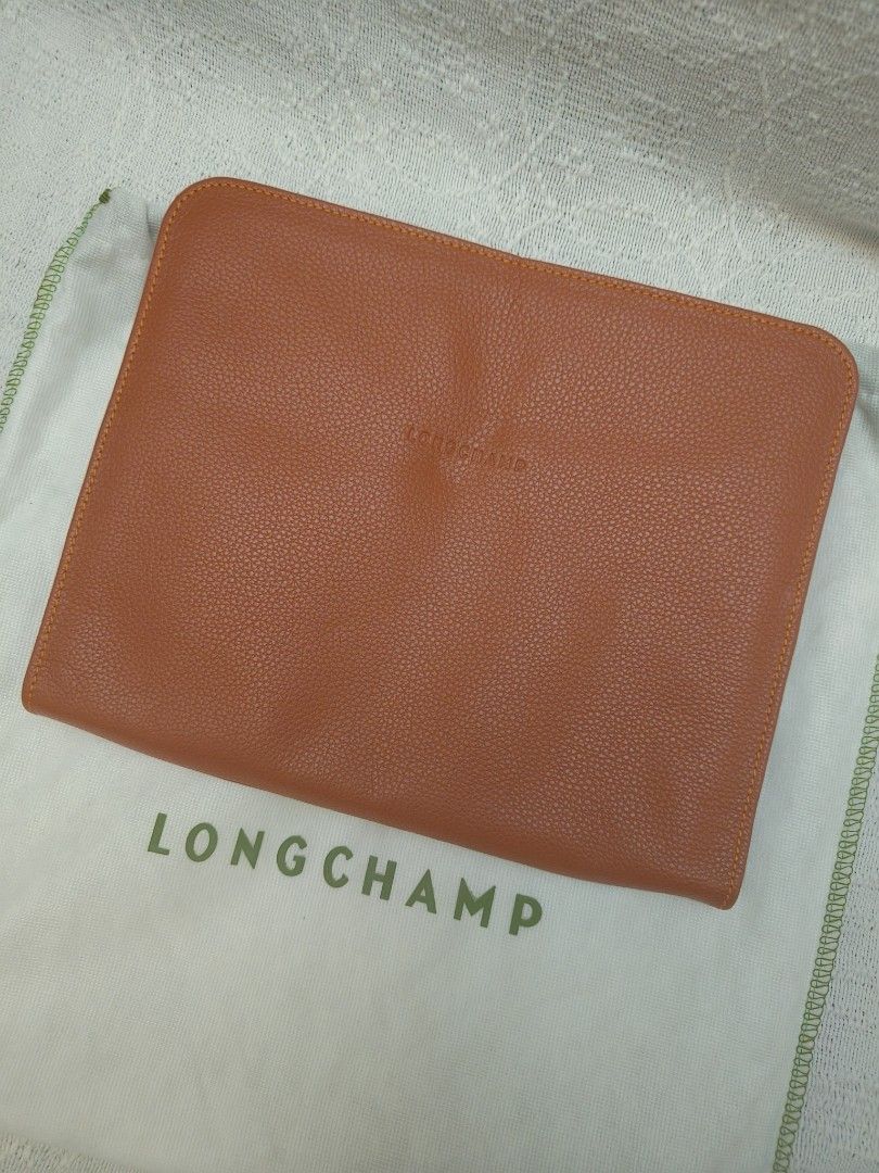 Longchamp Leather Clutch (Category: Luxury Bags & Wallets) located in Makati City. Submitted by emem.pre.owned.ph (Listing ID 1433888275, Image 1). Description: - Longchamp clutch - Orange leather - Zip closure - Multiple interior compartments - Longchamp logo detail - Includes dust bag.