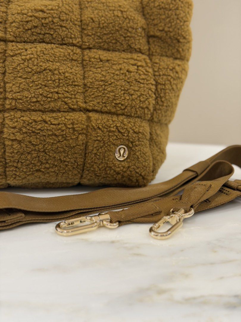 Lululemon Quilted Tote Bag (Category: Tote Bags) located in Manila. Submitted by decluttersiris (Listing ID 1433802591, Image 2). Description: - Lululemon quilted tote bag - Detachable shoulder strap - Zippered main compartment - Interior pocket - Soft, textured material - Gold-tone zipper - Contrasting interior lining - Features Lululemon logo.