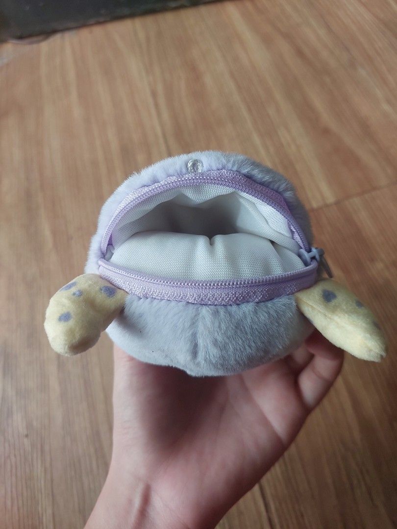 Mumuso Wallet (pre - owned) (Category: Purses & Pouches) located in Manila. Submitted by melissaga98708 (Listing ID 1433862390, Image 2). Description: - Adorable moon face plush pouch - Soft and fluffy material - Light blue body with purple eyes and pink mouth - Features two small, spotted yellow appendages - Secure zipper closure - Ideal for coins, keys, cosmetics, and other small items.