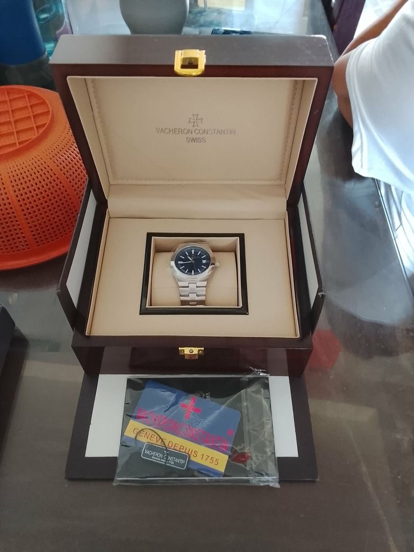 Vacheron Constantin Watch Box (Category: Luxury Watches) located in Bauang. Submitted by missisv (Listing ID 1433893730, Image 2). Description: - Authentic Vacheron Constantin watch box - Dark wood finish - Intricate gear design on lid - Features Vacheron Constantin logo and "Swiss" text Brand: Vacheron Constantin Collection: Overseas Model Reference: Commonly 47040/000A-9008 or 5520V/210A-B148 (depending on exact version) Case Material: Stainles
