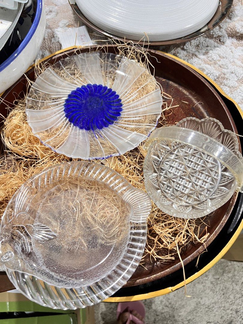 Vintage Glass Plates Set (Category: Dinnerware & Cutlery) located in Manila. Submitted by suarezbaby04975 (Listing ID 1433888554, Image 1). Description: - Vintage glass plate set - Includes: - Fish-shaped plate - Flower-shaped plate (blue center) - Small, patterned plate - Clear glass construction - Displayed on a brown tray with straw-like material.