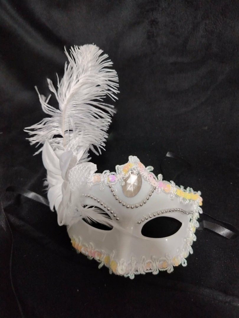 White Feathered Masquerade Mask (Category: Occasions & Party Supplies) located in Cavite. Submitted by samanthalacandula (Listing ID 1433945068, Image 1). Description: - White masquerade mask - Features feather and jewel details - Decorative embellishments - Comes with a black ribbon - Ideal for parties and events.