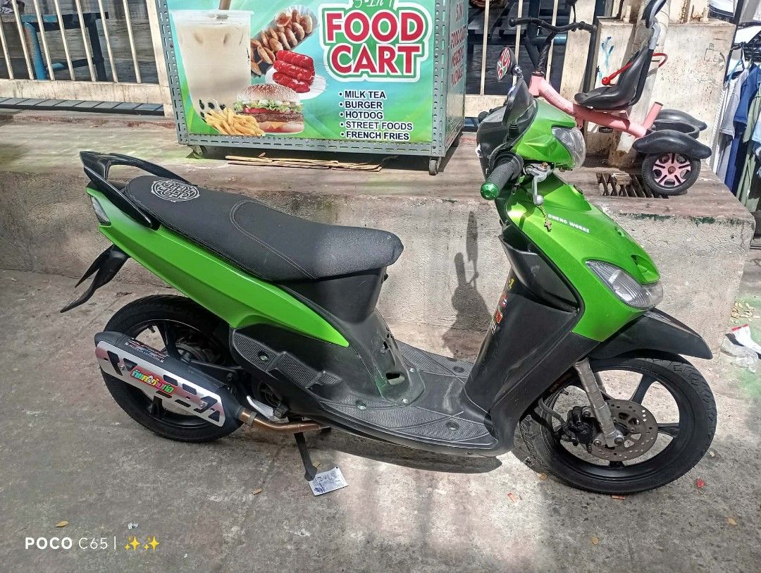 Yamaha Mio Motorcycle - Green (Category: Motorbikes for Sale) located in Manila. Submitted by jrjaqueli42535 (Listing ID 1433794905, Image 3). Description: Green and black Yamaha Mio motorcycle. Features a black seat and exhaust. The motorcycle is parked on a concrete surface. The images show the motorcycle from multiple angles..