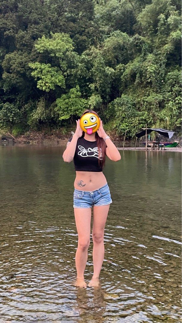Black Crop Top and Denim Shorts (Category: Sets or Coordinates) located in Manila. Submitted by usedstuffs (Listing ID 1433981774, Image 1). Description: - Black crop top with a white graphic design - Model wearing the outfit in a river - Suitable for casual wear.
