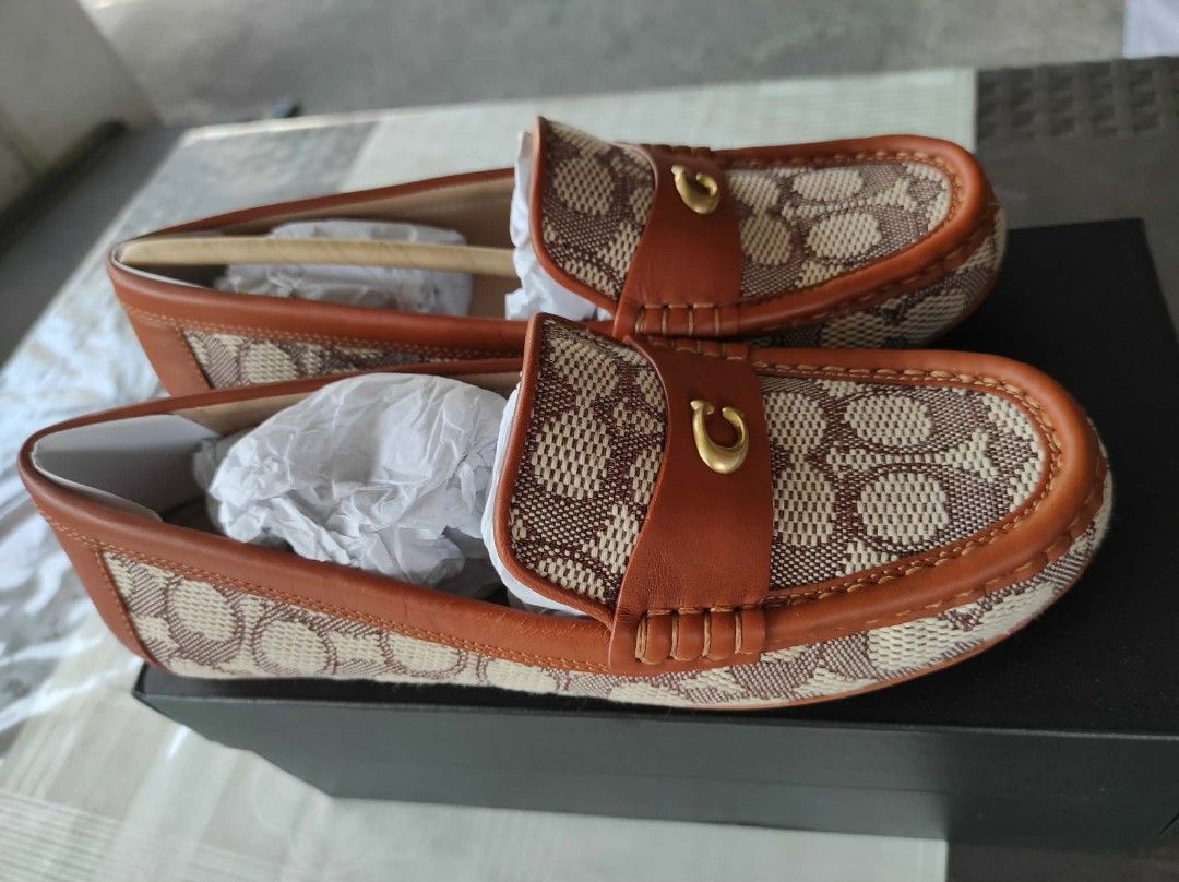 Coach Signature Loafers (Category: Loafers) located in General Mariano Alvarez. Submitted by deslacbayan (Listing ID 1434030216, Image 2). Description: - Coach loafers - Signature pattern - Brown leather trim - Gold-tone 'C' logo - New with original packaging - Classic style - Perfect for everyday wear.