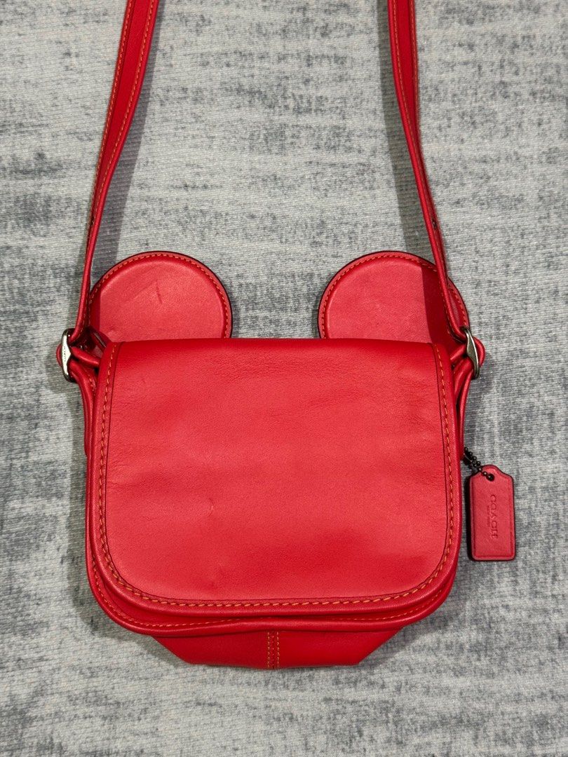 Coach x Disney - Limited Edition - Mickey Ears (Category: Cross-body Bags) located in Manila. Submitted by members-only (Listing ID 1434128433, Image 3). Description: DISNEY X COACH Mickey Mouse Ears Red Patricia Leather Saddle Crossbody Bag In good condition Flaws: Minor fold marks in front and minor rub in right ear (unnoticeable) check pics - Adjustable strap - Coach accessory still attach - No Rubbing in edges.