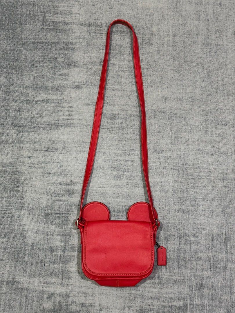 Coach x Disney - Limited Edition - Mickey Ears (Category: Cross-body Bags) located in Manila. Submitted by members-only (Listing ID 1434128433, Image 2). Description: DISNEY X COACH Mickey Mouse Ears Red Patricia Leather Saddle Crossbody Bag In good condition Flaws: Minor fold marks in front and minor rub in right ear (unnoticeable) check pics - Adjustable strap - Coach accessory still attach - No Rubbing in edges.