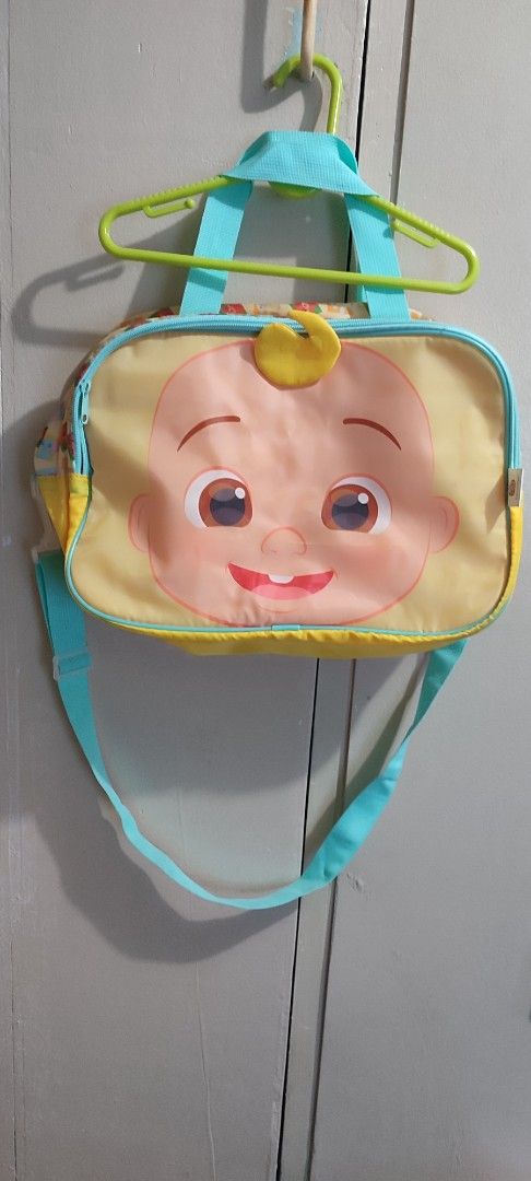 CoComelon Baby Face Shoulder Bag (Category: Babies & Kids Fashion) located in Mandaluyong City. Submitted by fml111213 (Listing ID 1433994417, Image 1). Description: - Adorable CoComelon shoulder bag - Features a cheerful baby face design - Light blue strap and handles - Yellow and light yellow body - Rectangular shape - Small yellow detail on top - Perfect for carrying essentials.