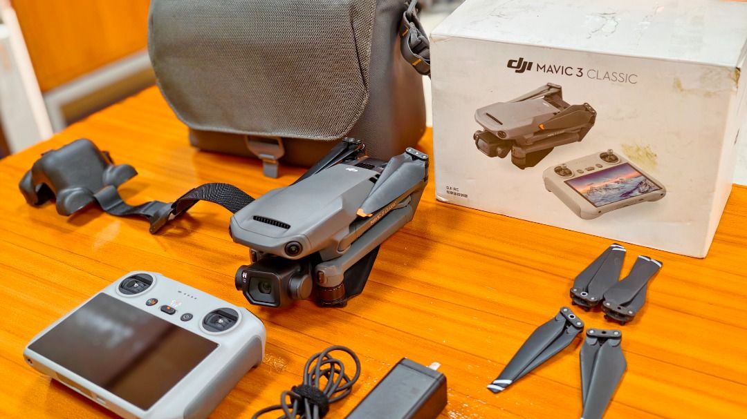 DJI Mavic 3 Classic Drone (Category: Drones) located in Mandaluyong City. Submitted by jrd_19 (Listing ID 1434032746, Image 1). Description: - DJI Mavic 3 Classic drone - Hasselblad 4/3 CMOS, 20 MP - Issue: Binded account, does not affect the drone's performance. - Includes remote controller with built-in screen(RC1) - Comes with battery, charger, and extra propellers - DJI Carrying bag and original box included - Color: Gray and black .