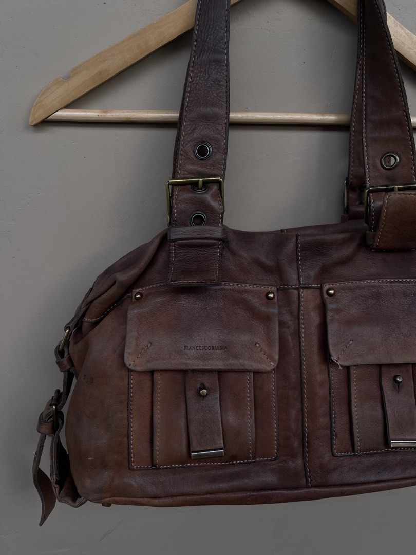 Fr*nces*o B*as*a Leather Handbag (Category: Luxury Bags & Wallets) located in Cagayan de Oro. Submitted by martinduarte22 (Listing ID 1433984795, Image 2). Description: - Francesco Biasia brown leather handbag - Two front pockets with flap closures - Buckle details on straps - Top handle design - Distressed leather - Spacious main compartment - Suitable for everyday use.
