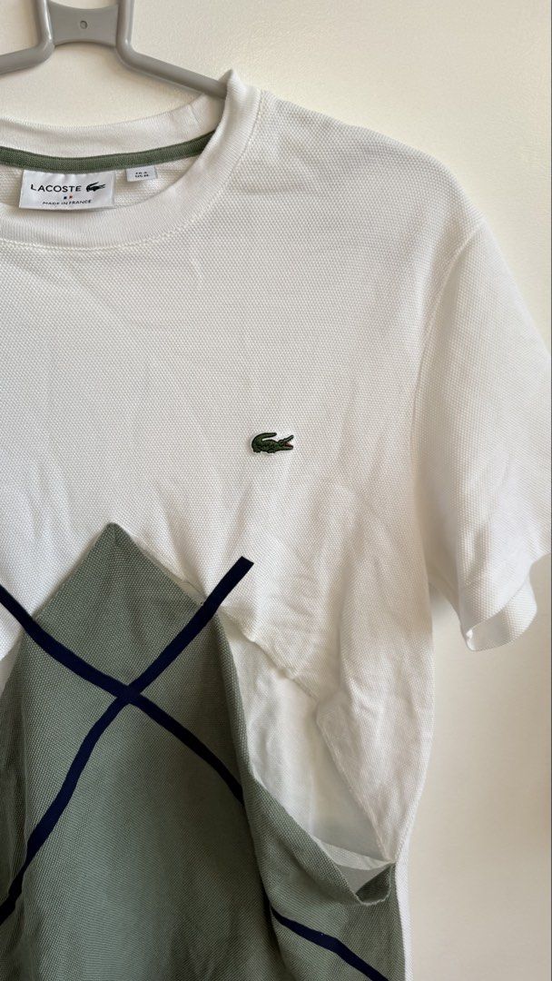 Lacoste Graphic T-Shirt (Category: Tshirts & Polo Shirts ) located in Valenzuela. Submitted by dees.corner (Listing ID 1434059344, Image 3). Description: - Lacoste graphic t-shirt - Unique geometric design in green and navy on a white body - Made in France - Size: US M - Fabric: Cotton and polyamide blend - Features: Crew neck, short sleeves - W17, L27 - Needs repair.